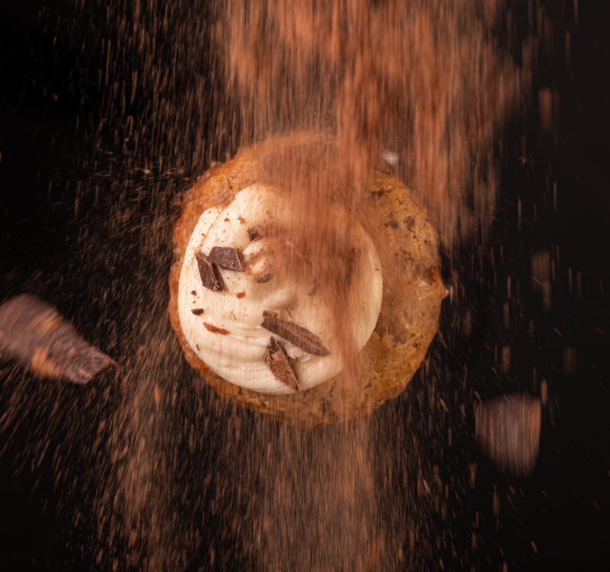 Canela cayendo sobre una galleta recién horneada